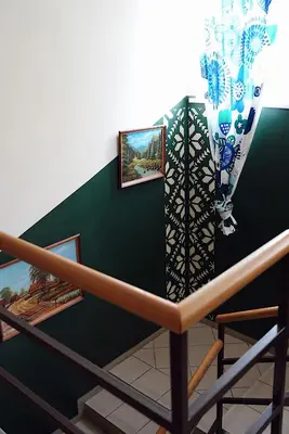 a stairwell with a green wall with a painting on it at GP Hostel in Šiauliai