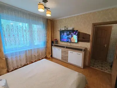 a bedroom with two beds and a tv and a window at Weekend Home in Visaginas