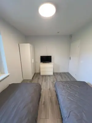 a bedroom with a bed and a television in it at Pušų Sodas in Birštonas