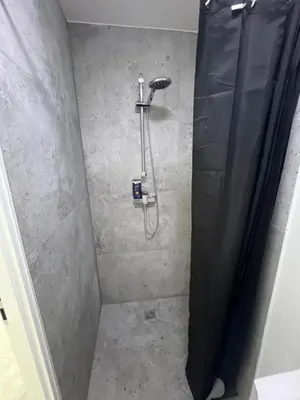 a shower in a bathroom with a shower curtain at Pušų Sodas in Birštonas