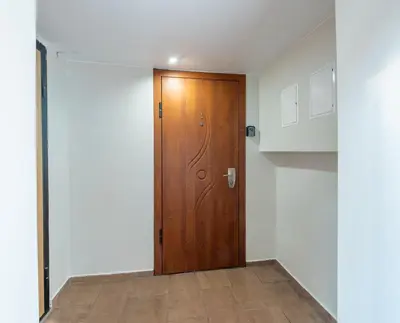 a wooden door in a room with white walls at Opera Escape Studio in Vilnius