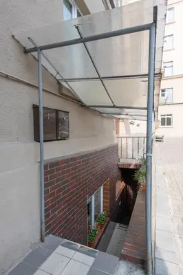 awning on the side of a building with a brick wall at Opera Escape Studio in Vilnius