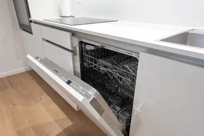 an empty dishwasher in a kitchen under a counter at Opera Escape Studio in Vilnius