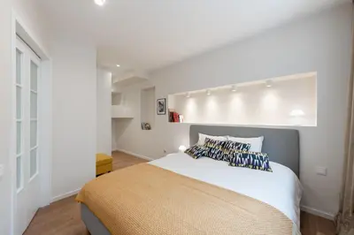 a bedroom with a large bed in a white room at Opera Escape Studio in Vilnius