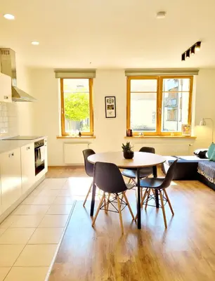 a kitchen and living room with a table and chairs at Amber Self Check-in Oldtown in Vilnius