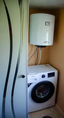a washing machine and a lamp in a room at Sodyba Gluosnis