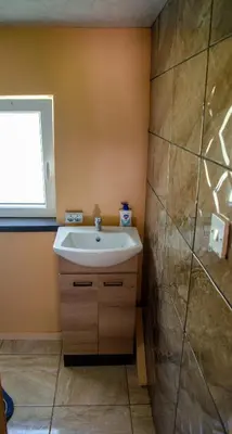 a bathroom with a sink and a window at Sodyba Gluosnis