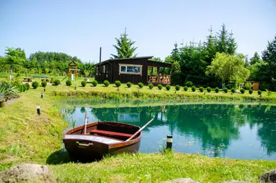 a small boat sitting on the grass in front of a house at Sodyba Gluosnis