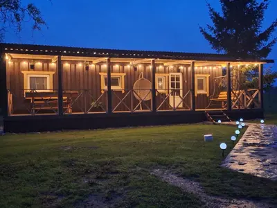 a wooden cabin with lights on the front of it at Sodyba Gluosnis