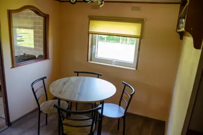a table and chairs in a room with a window at Sodyba Gluosnis