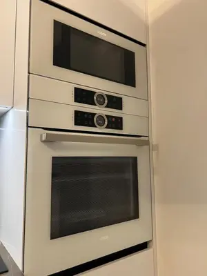 two ovens with a microwave above them in a kitchen at Nemuno Banga in Druskininkai