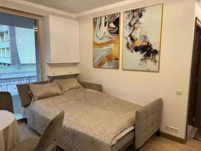 a bedroom with a bed and some pictures on the wall at Nemuno Banga in Druskininkai