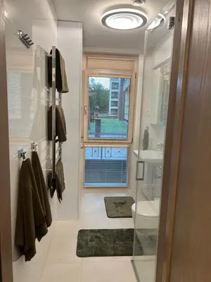 a bathroom with a toilet and a sink and a window at Nemuno Banga in Druskininkai