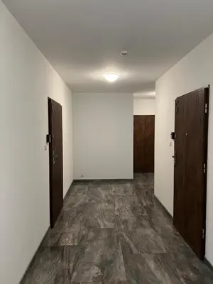 an empty room with two doors and a stone floor at Nemuno Banga in Druskininkai
