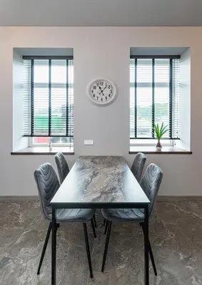 a dining room with a table and chairs and a clock at MnW apartment by Polo Apartments in Kaunas