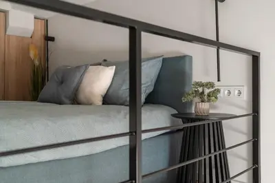 a bedroom with a blue bed with a table at Loft 13 in Vilnius