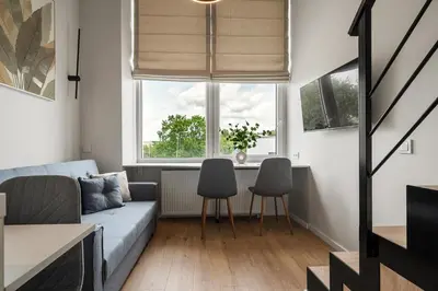 a living room with a couch and chairs and a window at Loft 13 in Vilnius