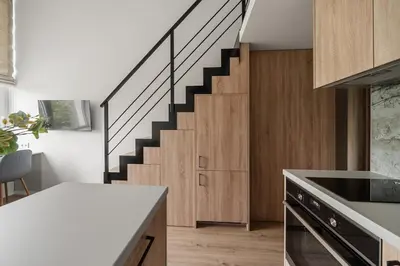 a kitchen with a spiral staircase in a house at Loft 13 in Vilnius