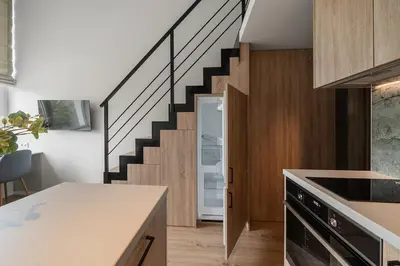 a kitchen with a staircase leading up to a house at Loft 13 in Vilnius