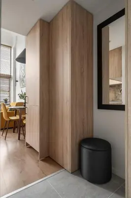a living room with wooden cabinets and a black stool at Loft 14 in Vilnius