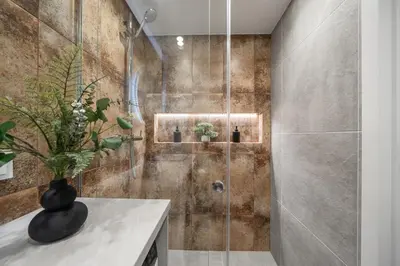 a shower with a glass door in a bathroom at Loft 14 in Vilnius