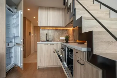 a kitchen with wooden cabinets and a staircase at Loft 14 in Vilnius