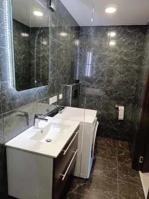 a bathroom with a white sink and a mirror at Alytus Miško studio in Alytus