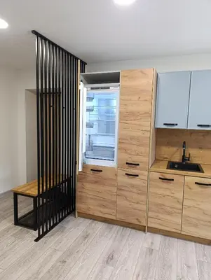 a kitchen with wooden cabinets and a sink and a window at Alytus Miško studio in Alytus