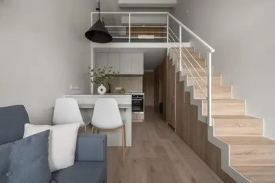 a kitchen and a living room with a staircase at Loft 12 in Vilnius