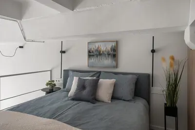 a bedroom with a bed and a painting on the wall at Loft 12 in Vilnius