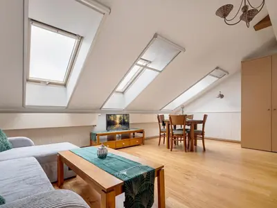 an attic living room with skylights and a table at Old Town Traku street apartment in Vilnius