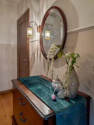 a table with a mirror and a vase on it at Old Town Traku street apartment in Vilnius