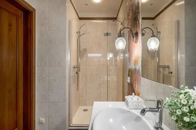 a bathroom with a shower and a sink and a mirror at Old Town Traku street apartment in Vilnius