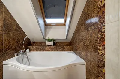 a bathroom with a white tub and a window at Old Town Traku street apartment in Vilnius