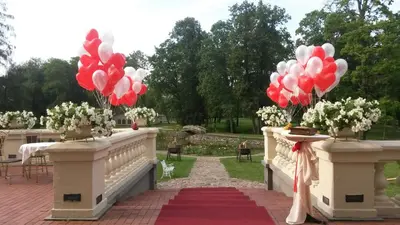 a bunch of red and white balloons on a bridge at Taujėnų dvaro rūmai in Towiany