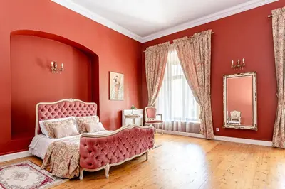 a red bedroom with a pink bed and a mirror at Taujėnų dvaro rūmai in Towiany