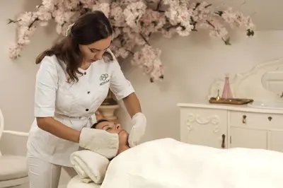 a woman in a spa treatment room with a woman laying on a bed at Taujėnų dvaro rūmai in Towiany