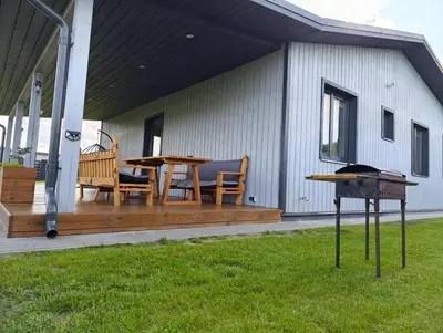 a deck with a table and chairs and a grill at Sodyba Miško pakrašty in Gailiūnai