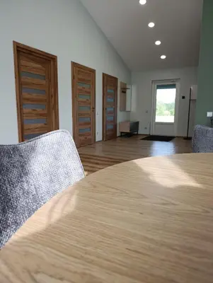a room with a table and two chairs and a hallway at Sodyba Miško pakrašty in Gailiūnai