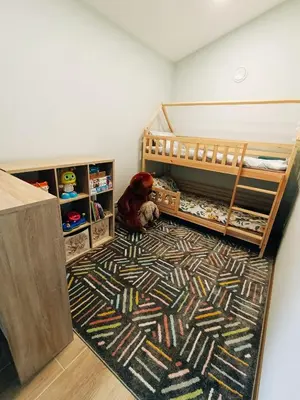 a bedroom with two bunk beds and a rug at Sodyba Miško pakrašty in Gailiūnai