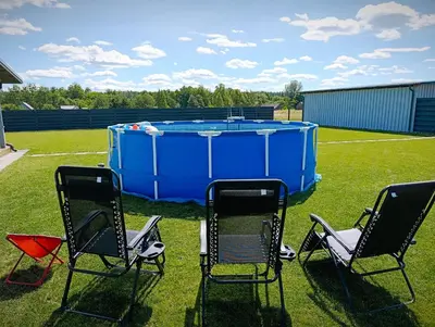 a group of chairs and a pool in a yard at Sodyba Miško pakrašty in Gailiūnai