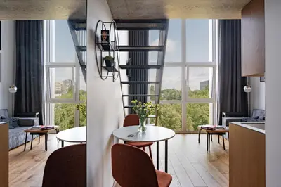 a living room with a spiral staircase and a table and chairs at Cinema Loft - Self Check in in Vilnius