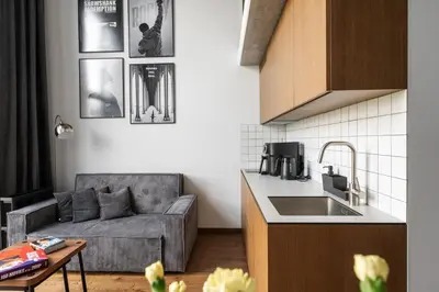 a living room with a couch and a kitchen at Cinema Loft - Self Check in in Vilnius