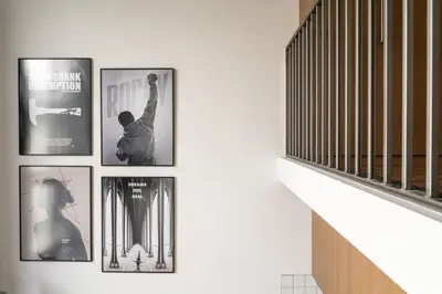 a group of framed pictures on a wall at Cinema Loft - Self Check in in Vilnius