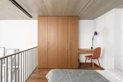 a bedroom with a wooden cabinet and a desk at Cinema Loft - Self Check in in Vilnius