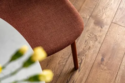 a brown chair sitting on top of a wooden floor at Cinema Loft - Self Check in in Vilnius
