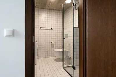 a bathroom with a toilet and a glass shower at Cinema Loft - Self Check in in Vilnius