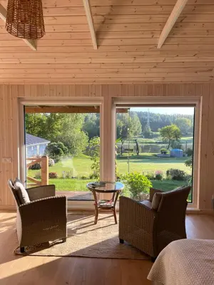 a bedroom with a large window with a view of a yard at Namelis prie Čiobiškio kelto