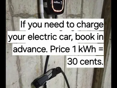 a sign that says if you need to charge your electric car book in advance at Happy Inn Sweet Old Town Studio, Self check in, Parking in Vilnius