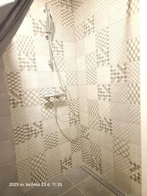 a shower with a hose in a bathroom at Happy Inn Sweet Old Town Studio, Self check in, Parking in Vilnius